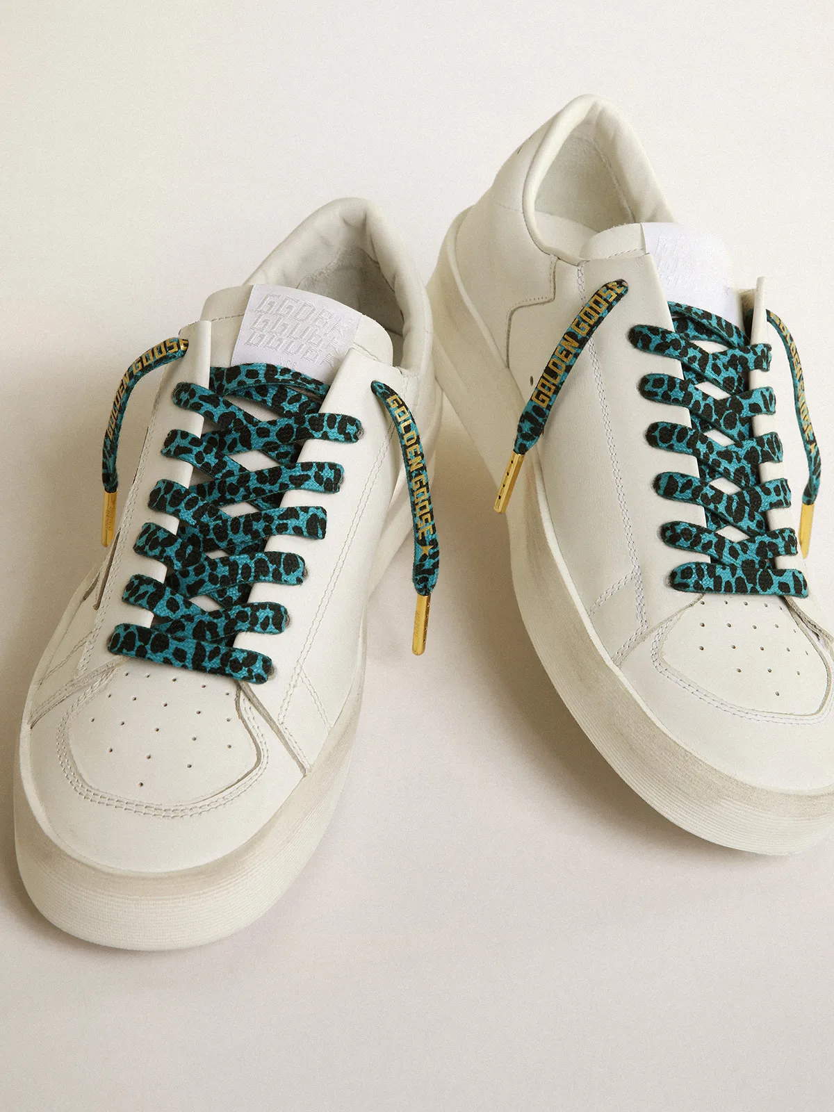 Light blue and black animal-print laces with contrasting gold-colored logo